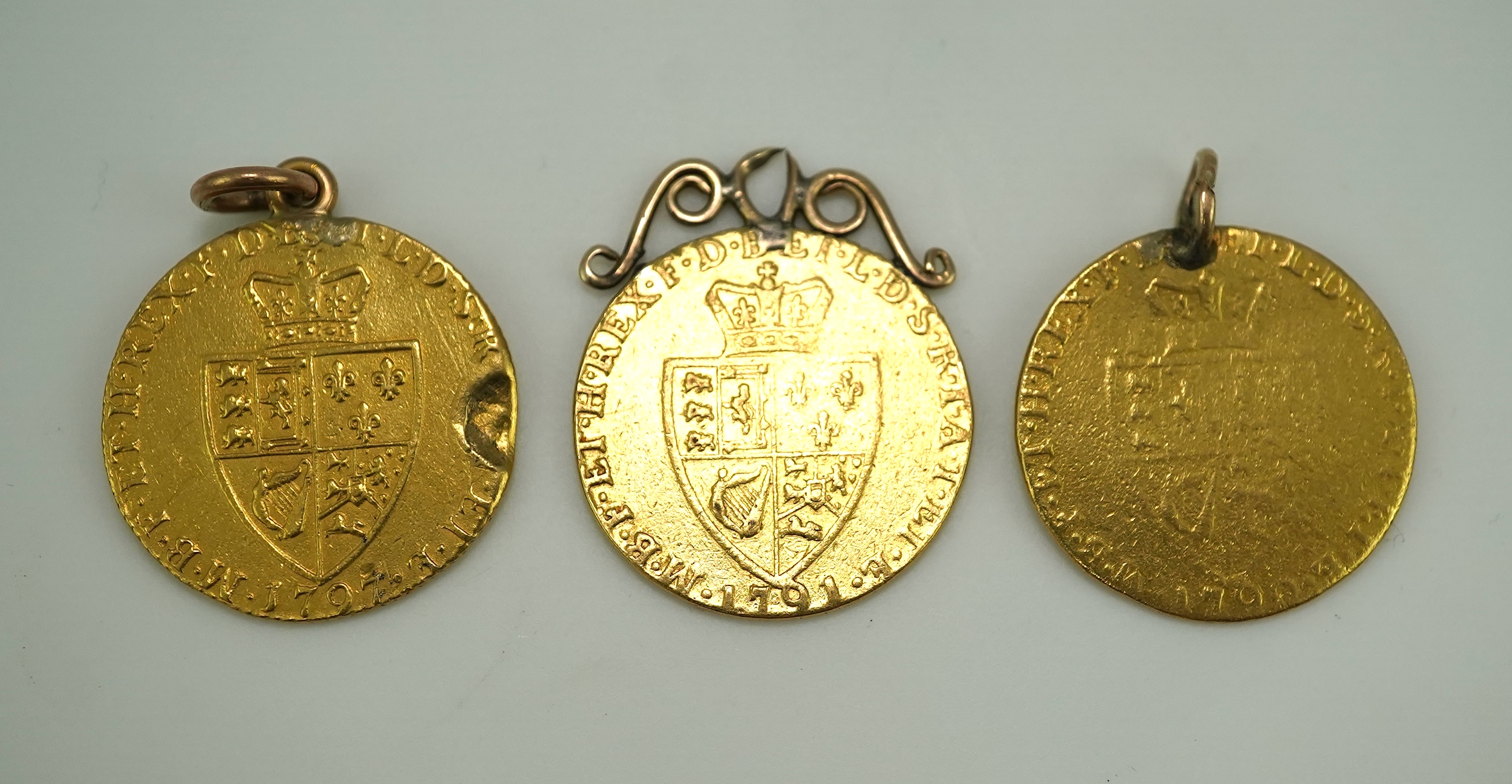 Three George III gold spade guinea coin pendants, late 18th/early 19th century and later